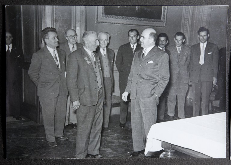 Reggio Emilia, 1955, Municipio di Reggio Emilia, Festeggiamenti per l'80° di Alcide Cervi. Papà Cervi parla con il sindaco di Reggio Cesare Campioli. Sono presenti Aldo Ferretti, Luigi Tagliavini, Bruno Melli, Giuseppe Tagliavini.